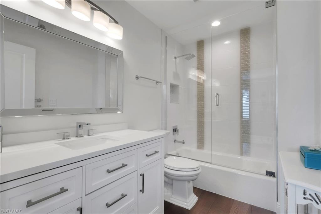 605 8th Avenue South, Unit 605 Naples, FL 34102 - Photo 31 of 50 Full bathroom with vanity, bath / shower combo with glass door, and dark wood-style floors