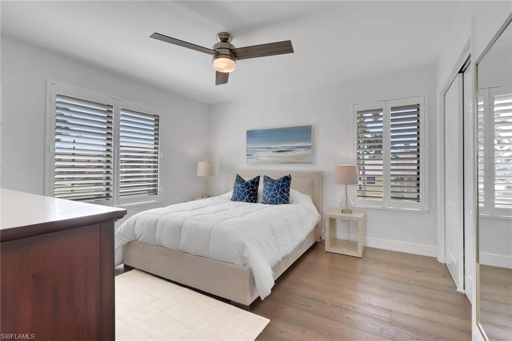 605 8th Avenue South, Unit 605 Naples, FL 34102 - Photo 34 of 50 Bedroom with light wood-style floors, a closet, and ceiling fan