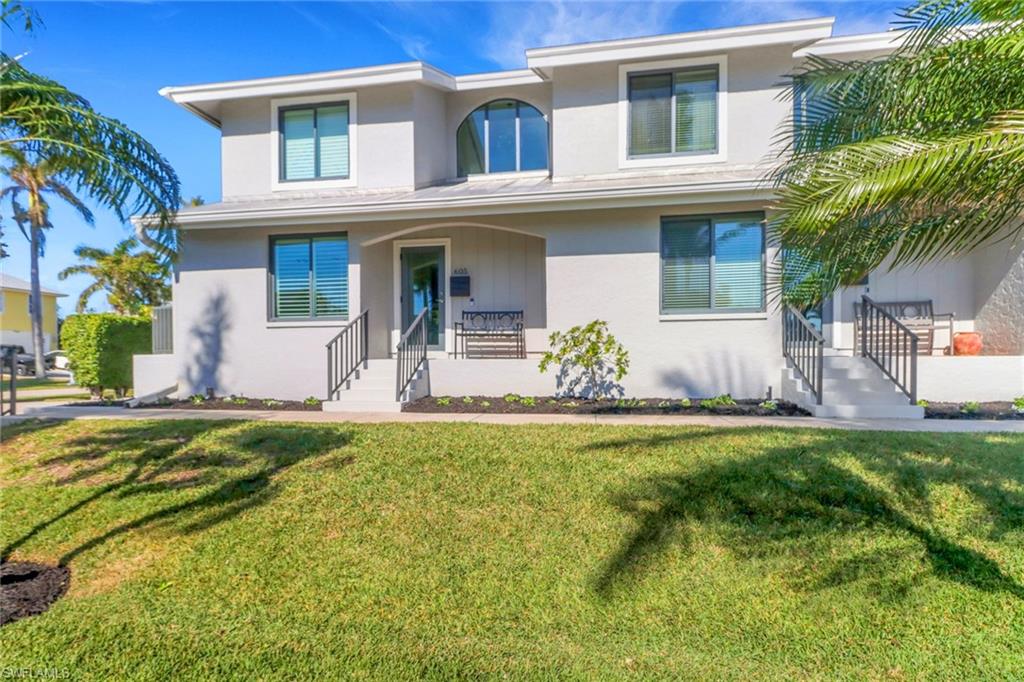 605 8th Avenue South, Unit 605 Naples, FL 34102 - Photo 37 of 50 View of front of property featuring covered porch, a front yard, and stucco siding