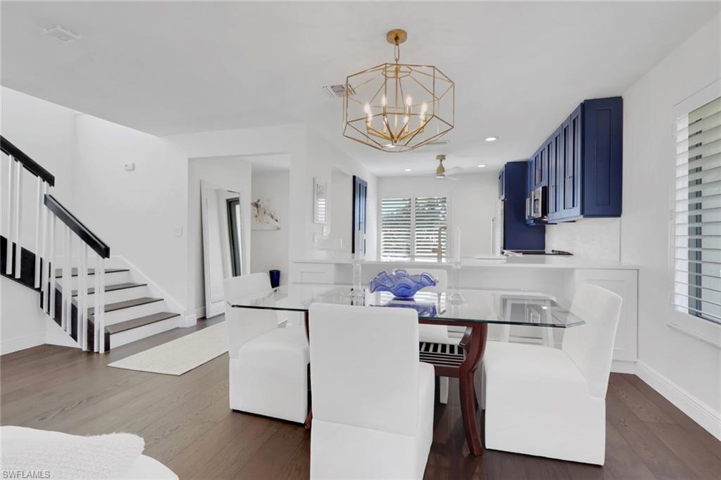 605 8th Avenue South, Unit 605 Naples, FL 34102 - Photo 6 of 50 Dining space with dark wood finished floors, a chandelier, stairway, and recessed lighting