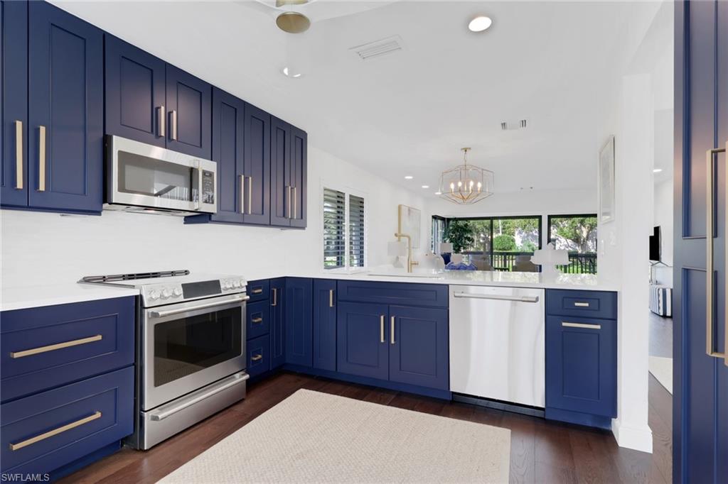 605 8th Avenue South, Unit 605 Naples, FL 34102 - Photo 9 of 50 Kitchen with blue cabinetry, stainless steel appliances, a chandelier, and recessed lighting