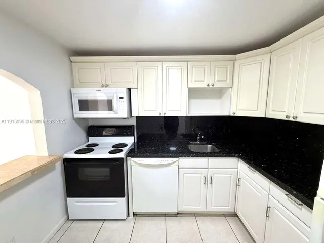 a kitchen with cabinets and white appliances