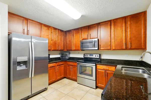 a kitchen with granite countertop cabinets stainless steel appliances and a sink