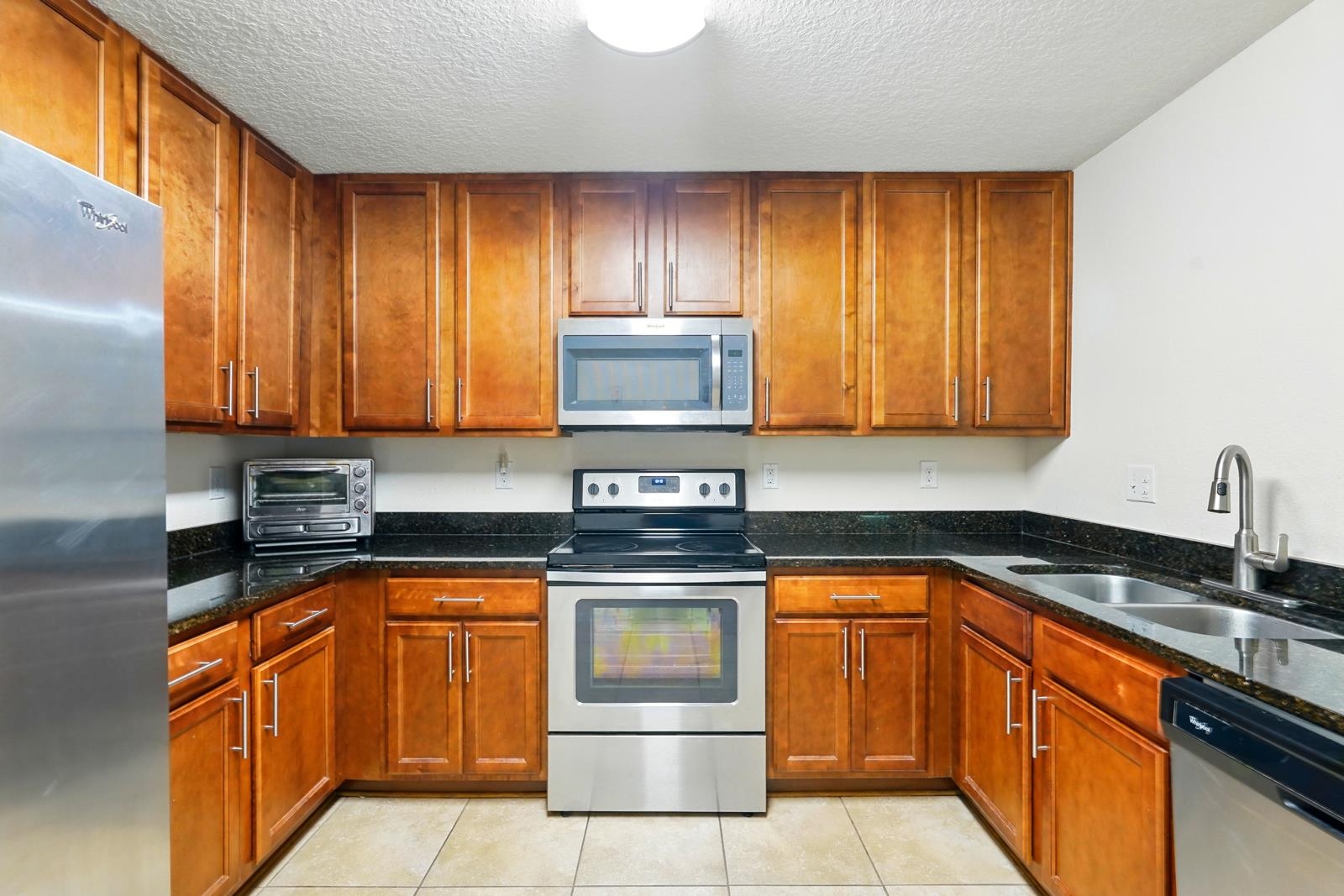 2103 Golden Lake Loop St. Augustine, FL 32084 - Photo 31 of 44 a kitchen with granite countertop stainless steel appliances wooden cabinets and a sink