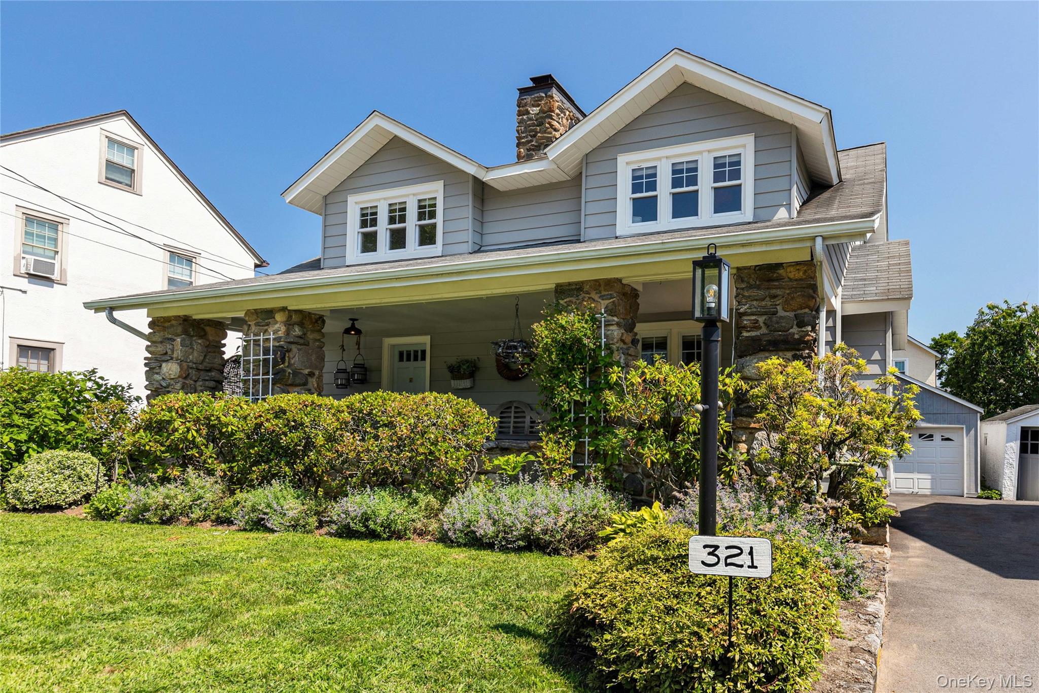 321 Rye Beach Avenue Rye, NY 10580 - Photo 35 of 36 View of front of home with a garage, stone siding, a chimney, and a front yard