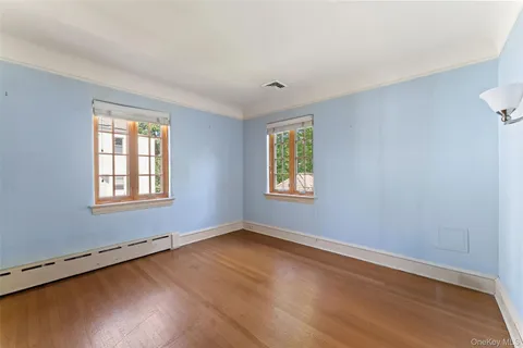 a view of a room with wooden floor and windows