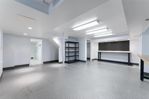 a view of an empty room with wooden floor and stairs