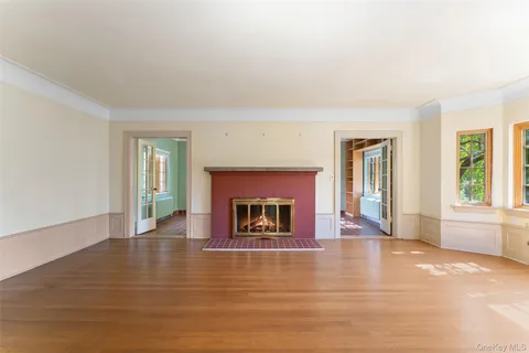 a view of an empty room with window and fire place