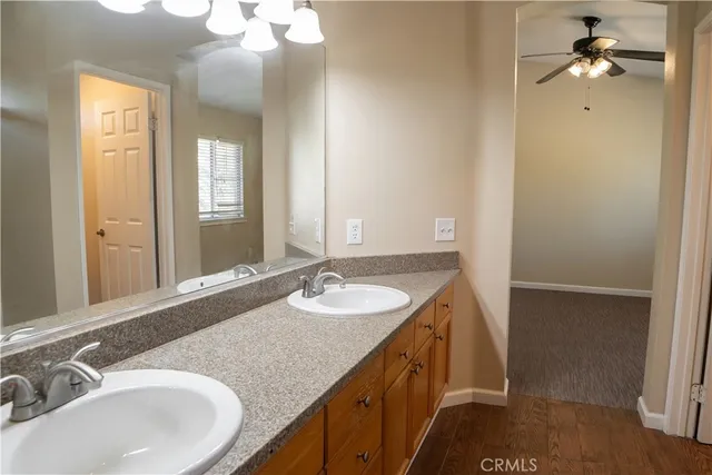 a spacious bathroom with a granite countertop sink a large mirror and a shower