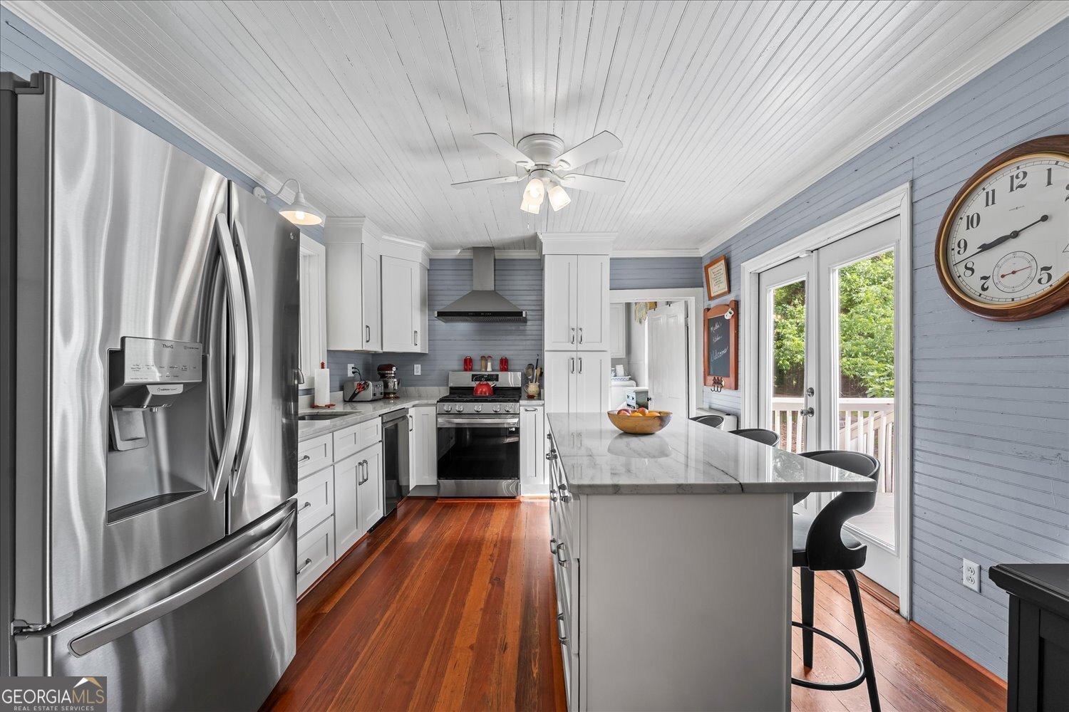6644 East Cadley Road Norwood, GA 30821 - Photo 25 of 53 a kitchen with granite countertop a refrigerator a stove a sink and a refrigerator with wooden floor