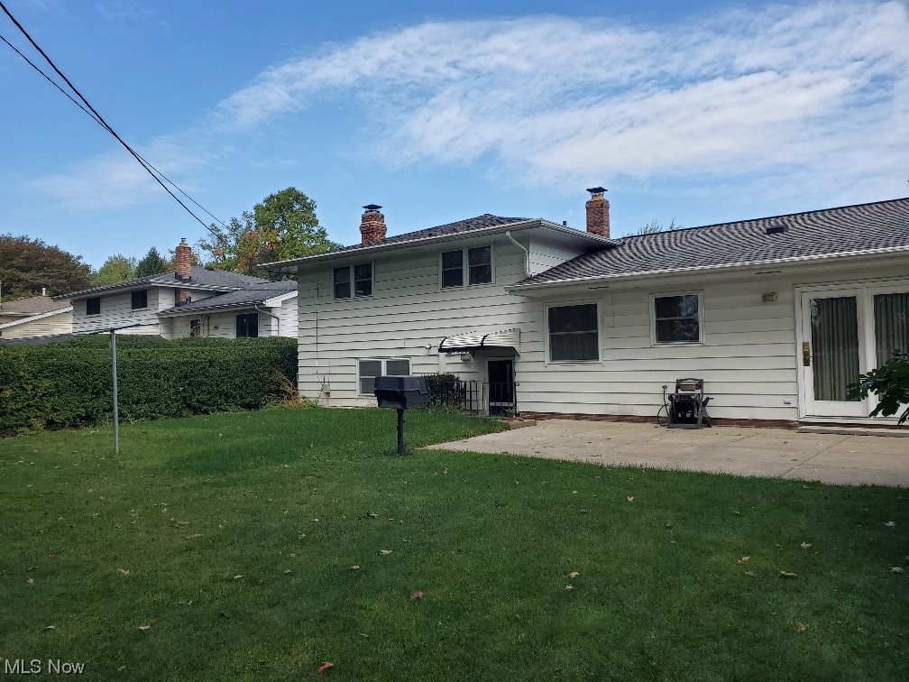 12221 Reno Drive Parma, OH 44130 - Photo 4 of 29 Rear view of house featuring a patio and a lawn