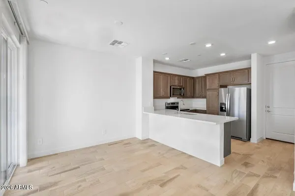 a room with kitchen island a sink stainless steel appliances and cabinets