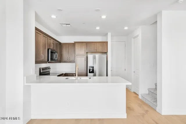 a kitchen with stainless steel appliances a refrigerator sink and microwave