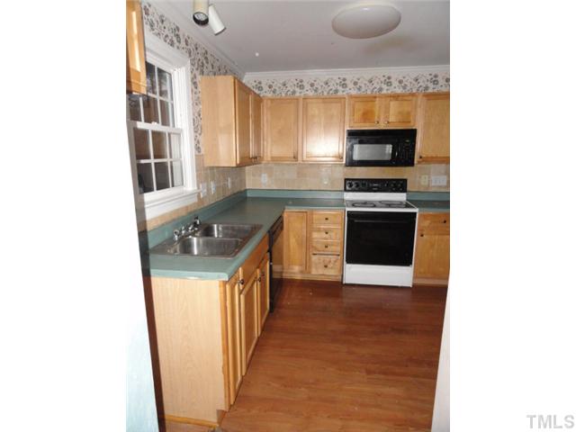 9341 Woodlief Road Wake Forest, NC 27587 - Photo 3 of 10 a kitchen with stainless steel appliances granite countertop a stove a sink and a microwave