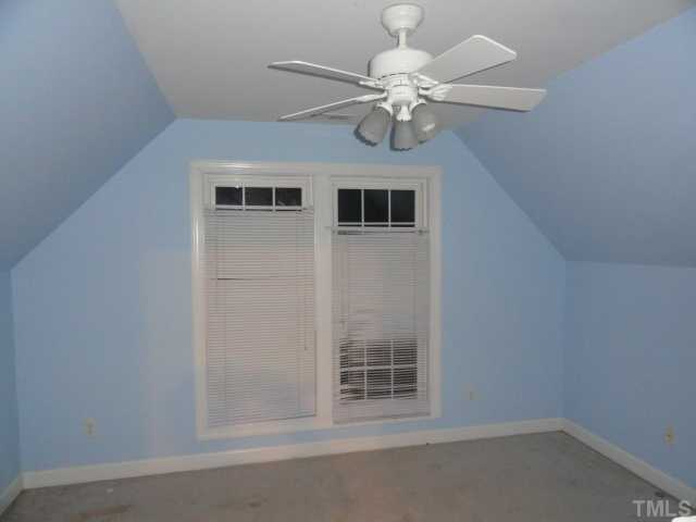 9341 Woodlief Road Wake Forest, NC 27587 - Photo 5 of 10 en empty room with windows and chandelier fan