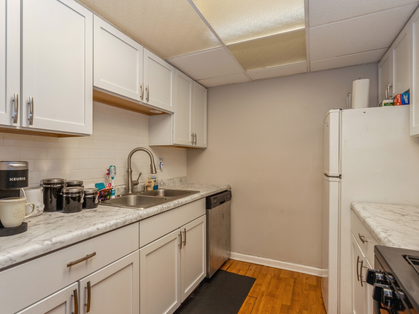 244 East Bailey Road, Unit H Naperville, IL 60565 - Photo 8 of 9 a kitchen with a sink a refrigerator and cabinets