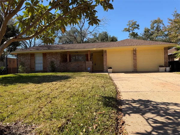a front view of house with yard and trees around