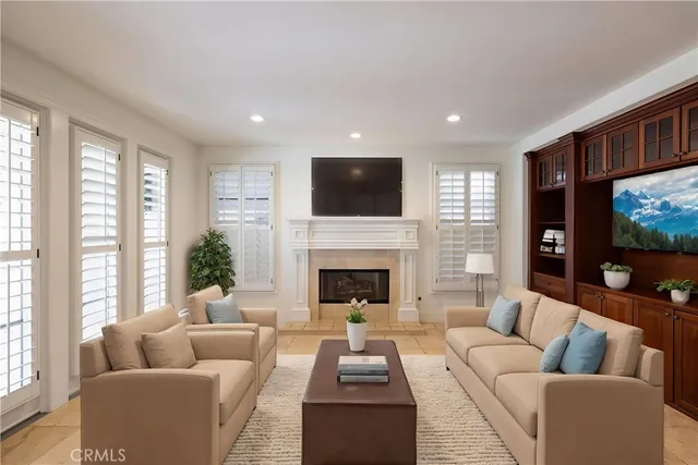 a living room with furniture a flat screen tv and a fireplace