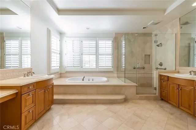 a spacious bathroom with a tub sink shower and mirror