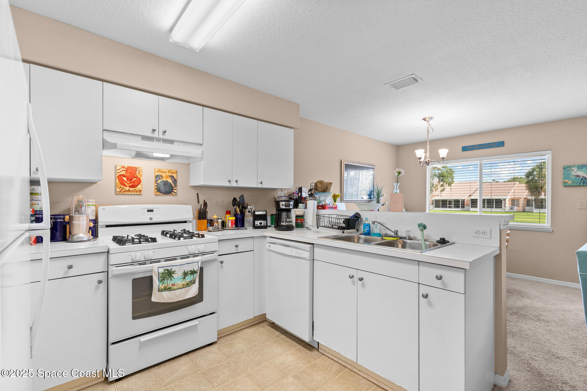 243 Forecast Lane, Unit 421 Rockledge, FL 32955 - Photo 12 of 43 a kitchen with appliances a sink and cabinets