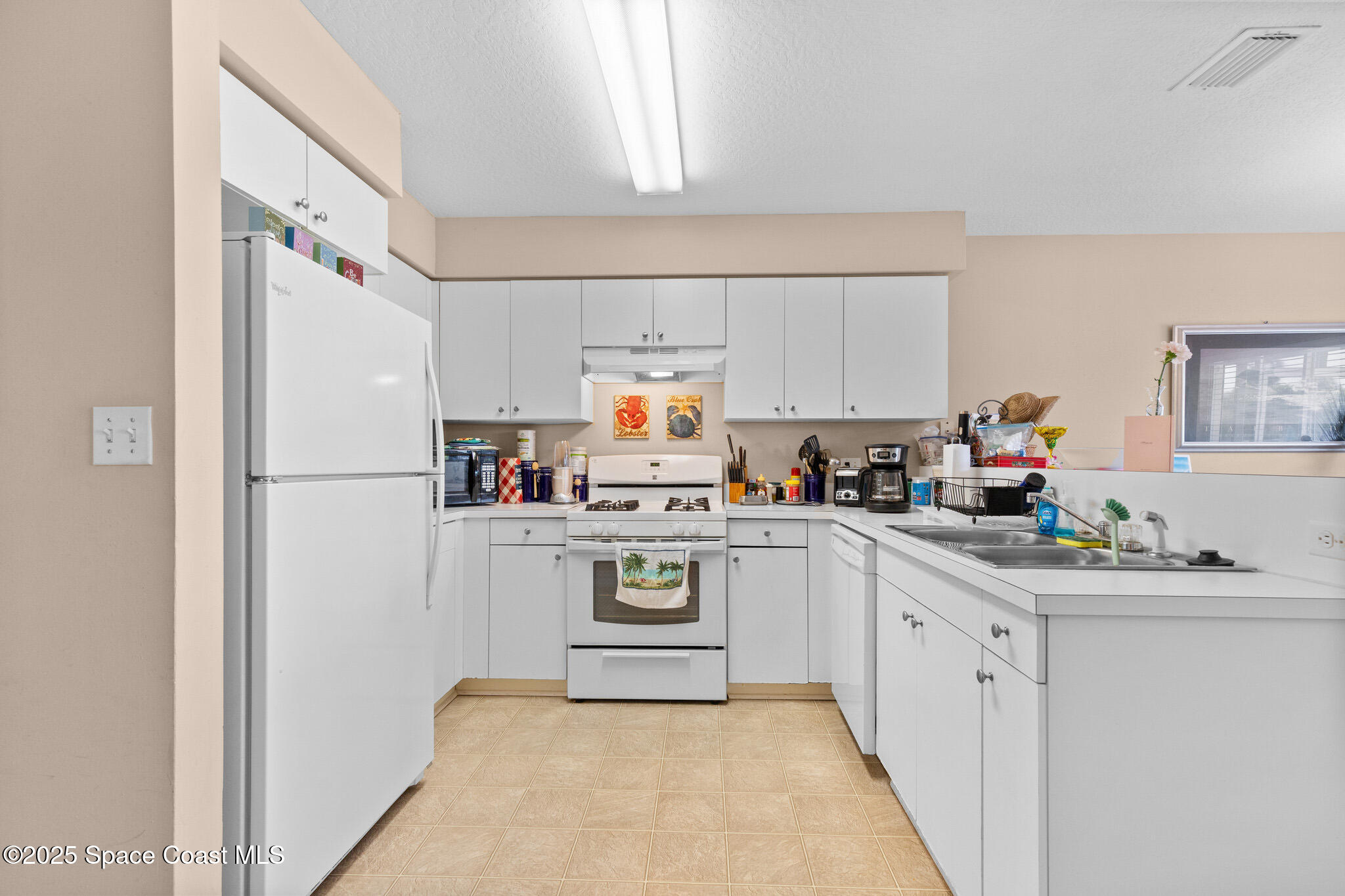 243 Forecast Lane, Unit 421 Rockledge, FL 32955 - Photo 13 of 43 a kitchen with white cabinets and white appliances