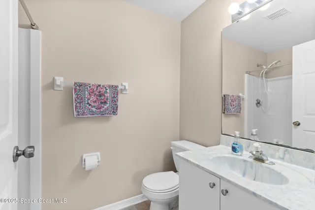 a bathroom with a granite countertop sink a toilet and a mirror