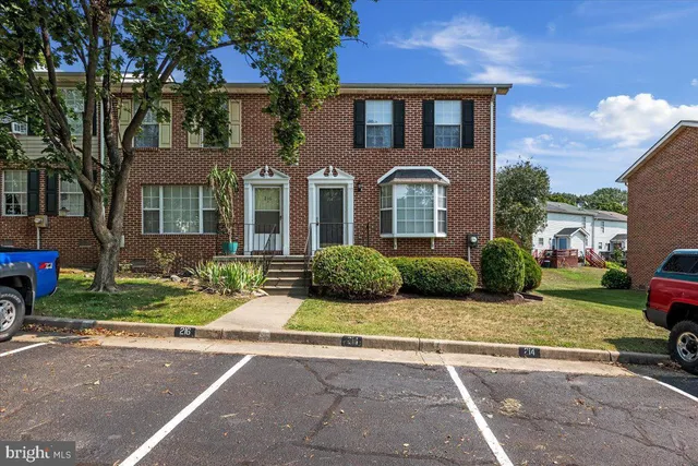 a view of a brick house with a yard next to a road