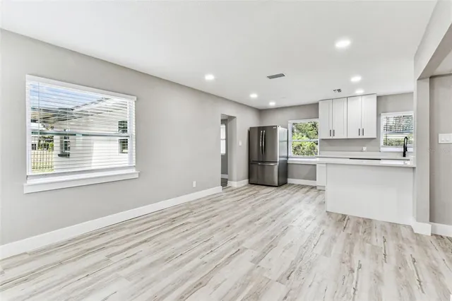 a kitchen with stainless steel appliances granite countertop a refrigerator a sink a stove and white cabinets