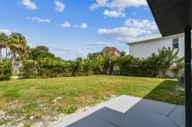an aerial view of a city with lots of residential buildings ocean and mountain view in back