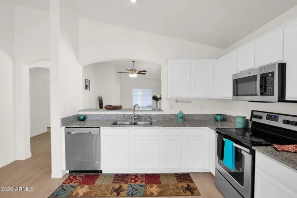 a kitchen with stainless steel appliances granite countertop a sink stove and microwave