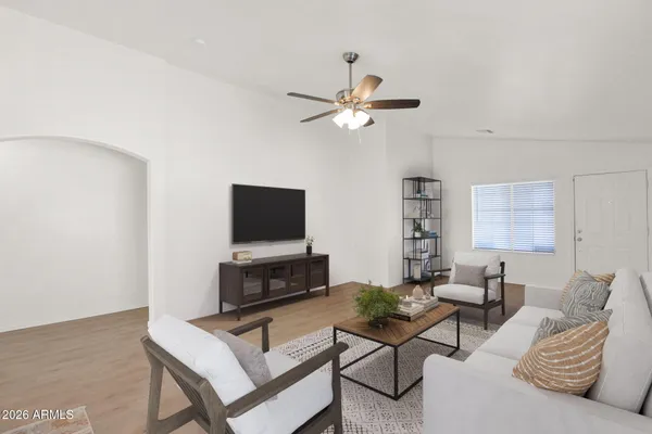 a living room with furniture a flat screen tv and a window