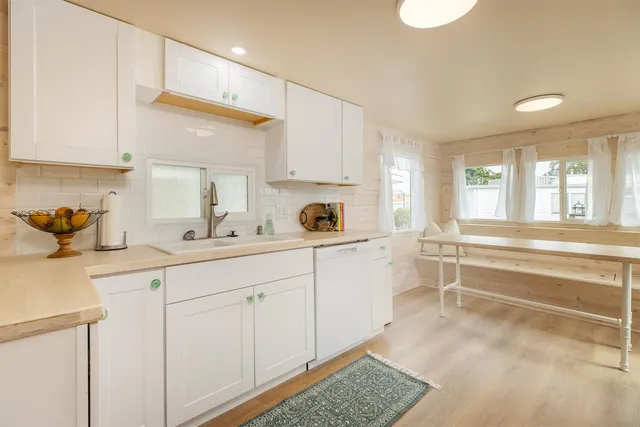 a kitchen with white cabinets and white appliances