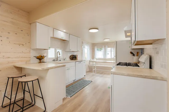 a kitchen with white cabinets and white appliances