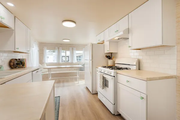 a kitchen with white cabinets and sink