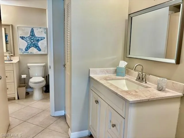 a bathroom with a granite countertop sink a toilet and shower