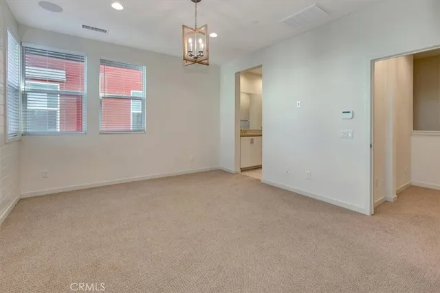 a view of empty room with chandelier fan