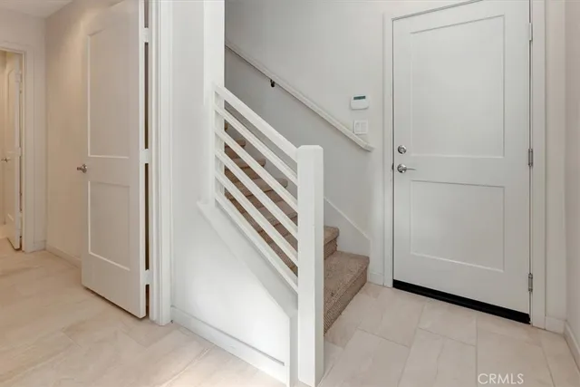 a view of a hallway with entryway and stairs