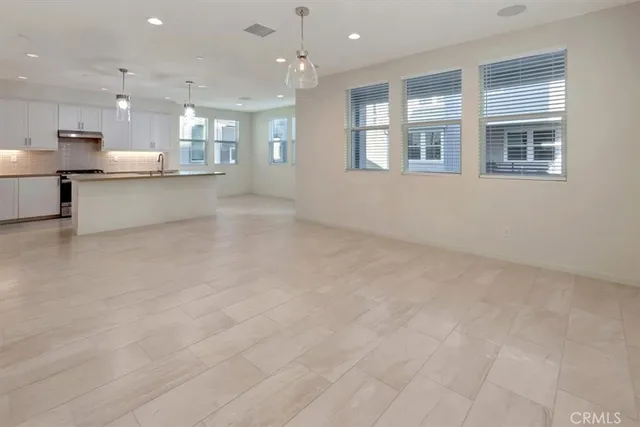 a view of kitchen with kitchen island large windows sink and refrigerator