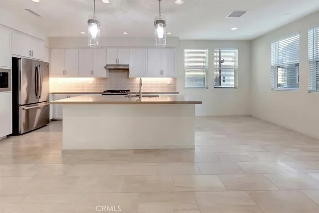 a kitchen with stainless steel appliances granite countertop a sink a stove a refrigerator and cabinets