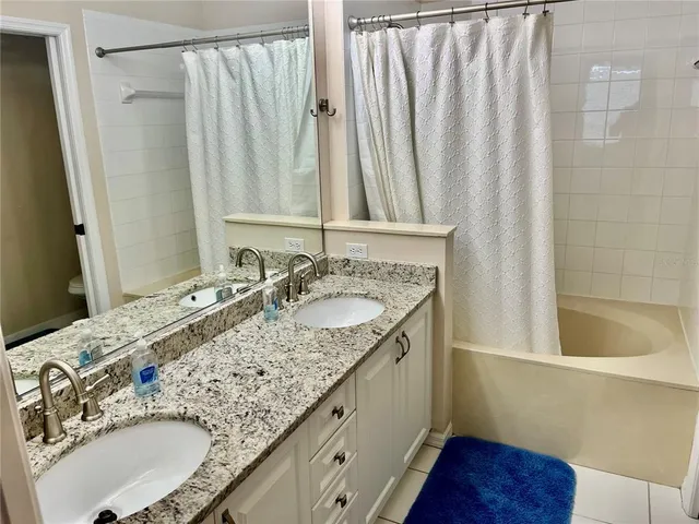 a view of a yard with plants and a lawn chair under an umbrella