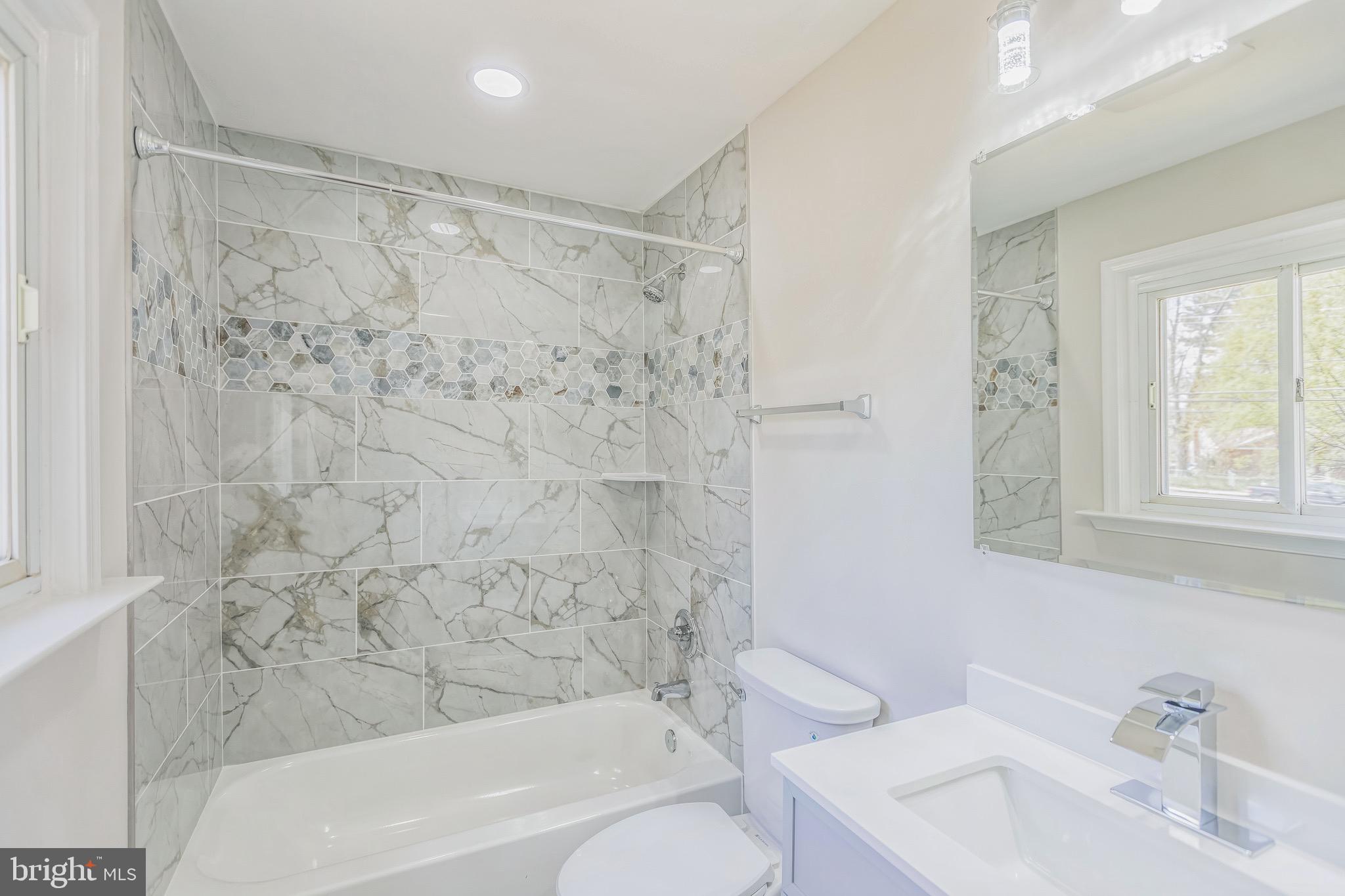 11308 Veirs Mill Road Silver Spring, MD 20902 - Photo 20 of 21 a bathroom with a bathtub shower sink vanity and toilet