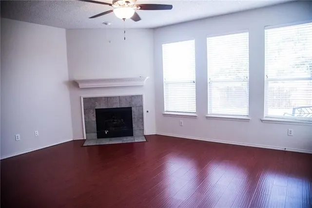 an empty room with windows and fireplace