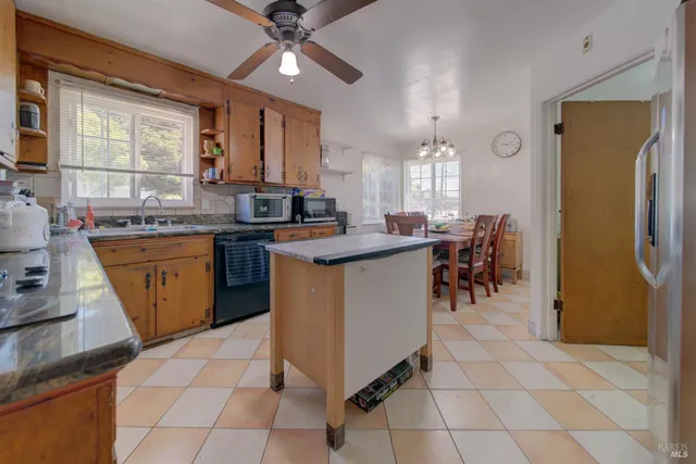 a kitchen with granite countertop a sink stove and cabinets