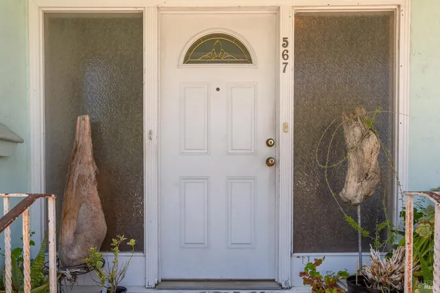 a view of a hallway with wooden floor and a livingroom