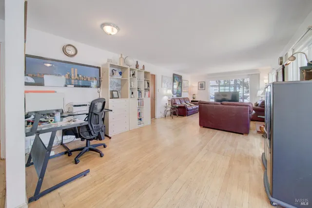 a living room with furniture a bookshelf and a window
