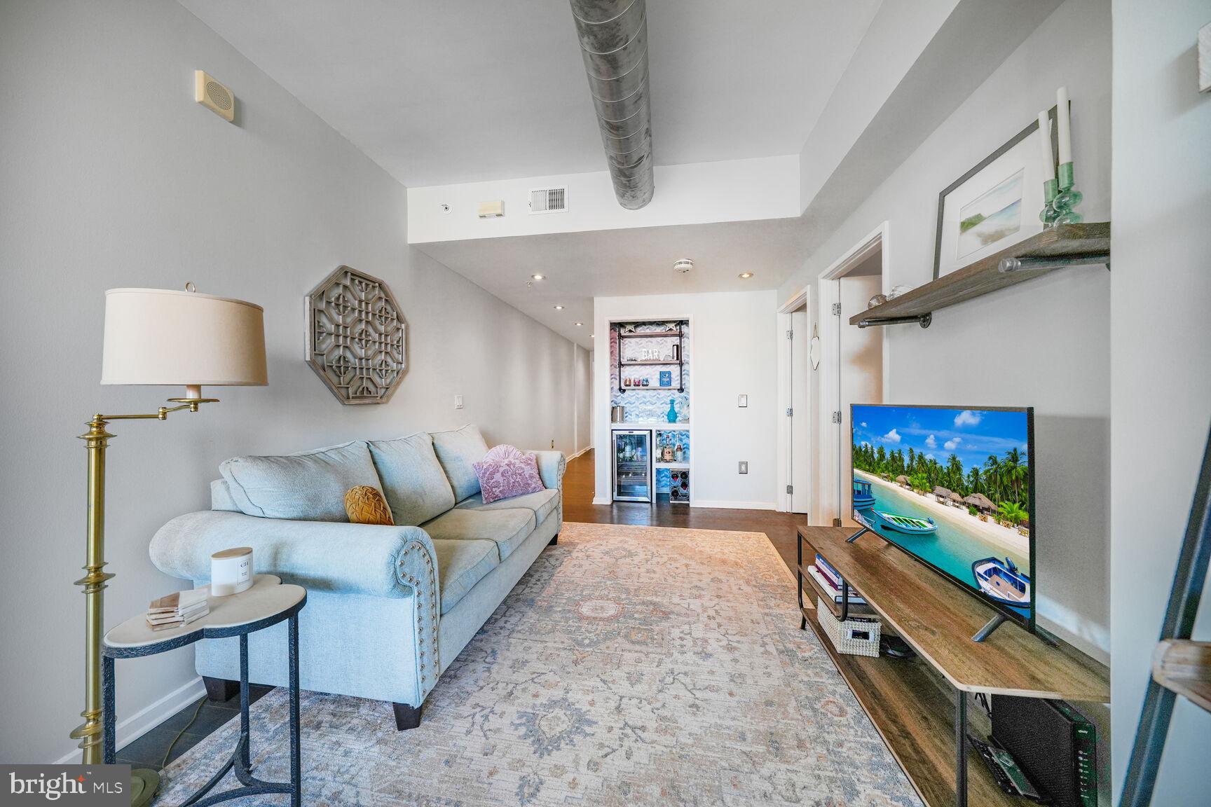 3409 Wilson Boulevard, Unit 211 Arlington, VA 22201 - Photo 3 of 30 a living room with furniture and a flat screen tv