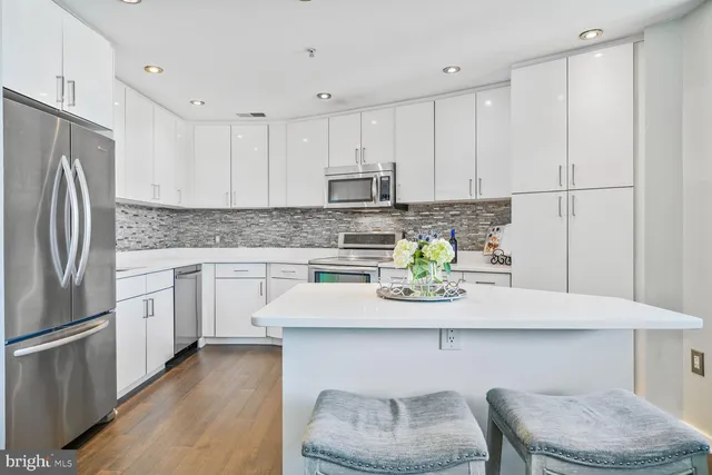 a kitchen with stainless steel appliances granite countertop a white refrigerator a sink a stove a dining table and chairs