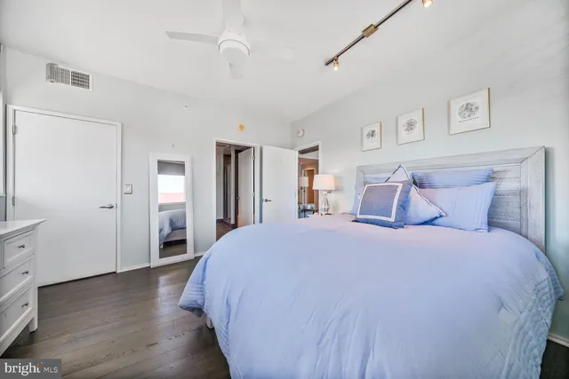 a spacious bedroom with a bed and wooden floor