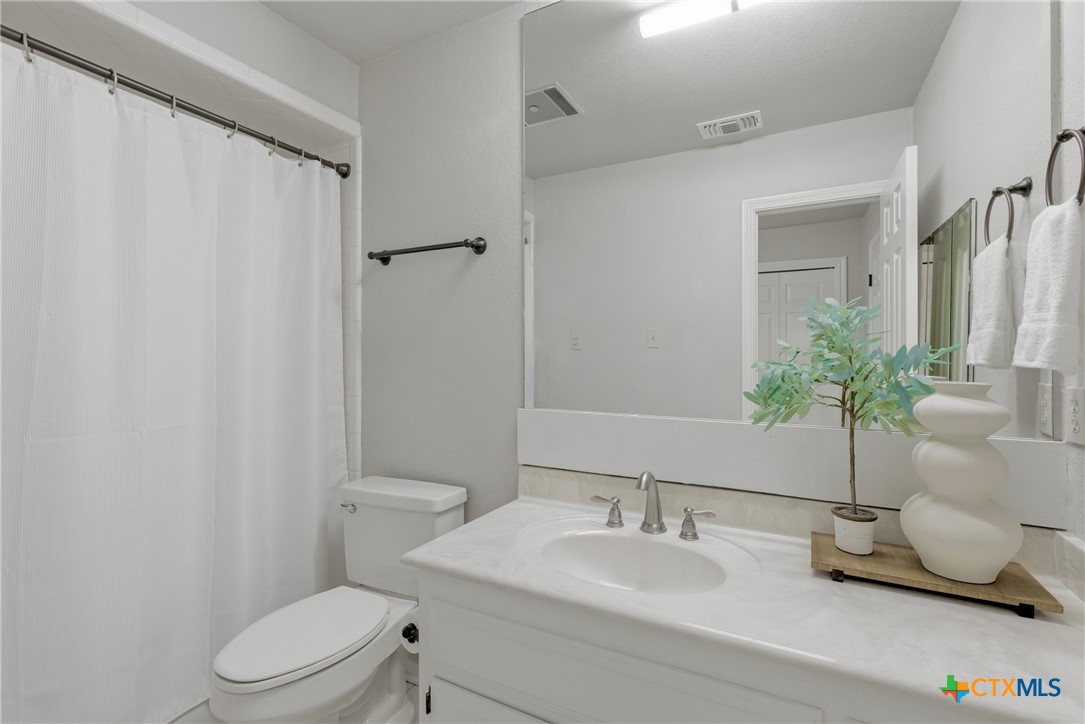 1710 Old Mill Road, Unit 12 Salado, TX 76571 - Photo 28 of 42 a bathroom with a granite countertop sink mirror vanity and toilet