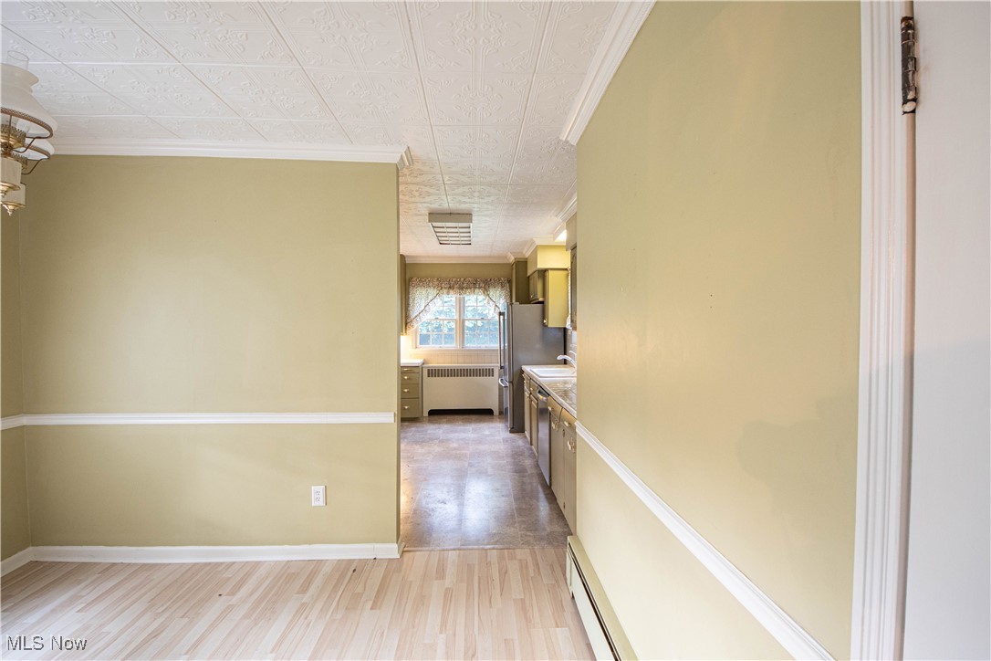 9719 Angling Road Wakeman, OH 44889 - Photo 10 of 39 Kitchen featuring ornamental molding, light wood-style floors, radiator, baseboard heating, and an ornate ceiling